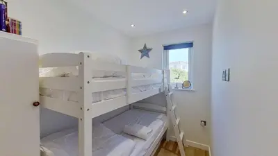 a white bunk bed in a room with a window at D08 Dawn O Day, Riviere Towans in Hayle