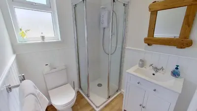 a bathroom with a shower and a toilet and a sink at D08 Dawn O Day, Riviere Towans in Hayle