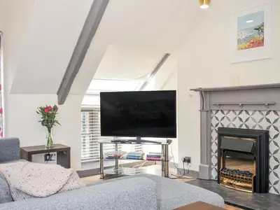 a living room with a tv and a fireplace at Beach Retreat in Looe