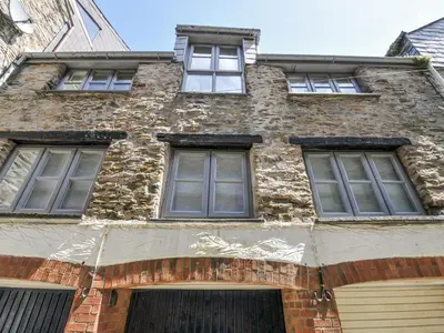 an old brick building with four windows on it at Beach Retreat in Looe