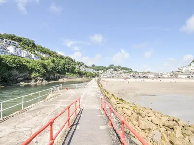 a walkway to the beach with people on the beach at Beach Retreat in Looe