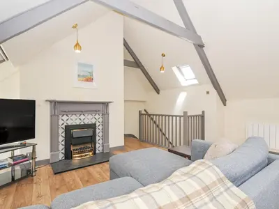 a living room with a fireplace and a tv at Beach Retreat in Looe