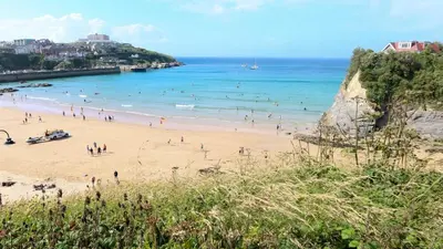 a group of people on a beach near the ocean at Modern surf pad, steps from Towan beach in Newquay