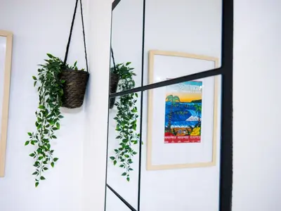 a room with a mirror and plants on the wall at Modern surf pad, steps from Towan beach in Newquay