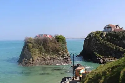 a house on a small island in the ocean at Modern surf pad, steps from Towan beach in Newquay