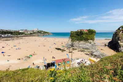 a beach with a bunch of people on the sand at Modern surf pad, steps from Towan beach in Newquay