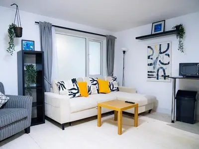 a living room with a white couch and a table at Modern surf pad, steps from Towan beach in Newquay