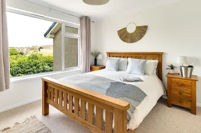 a bedroom with a bed and a large window at Cornish house, close to beaches - Ashfield Villas in Falmouth