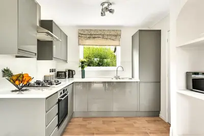 a kitchen with white appliances and a window at Cornish house, close to beaches - Ashfield Villas in Falmouth