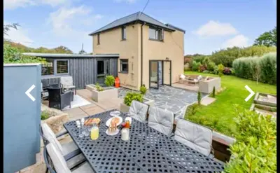 a backyard with a table and chairs and a house at St Ives Countryside Home with Pool Table & Parking in Towednack