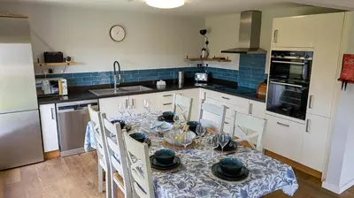 a kitchen with a table with chairs and a kitchen with at St Ives Countryside Home with Pool Table & Parking in Towednack