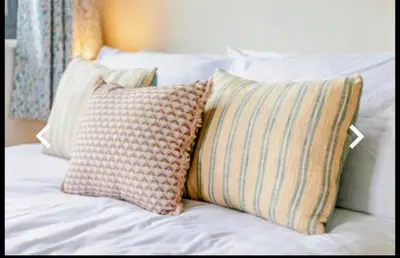 a pile of pillows sitting on top of a bed at St Ives Countryside Home with Pool Table & Parking in Towednack