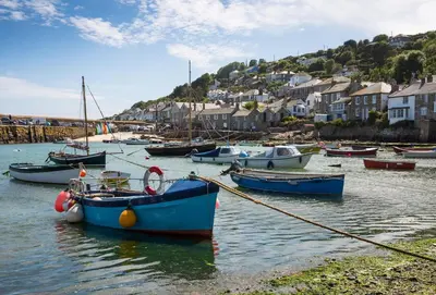 a group of boats docked in a harbor with houses at Acton Castle in Praa Sands