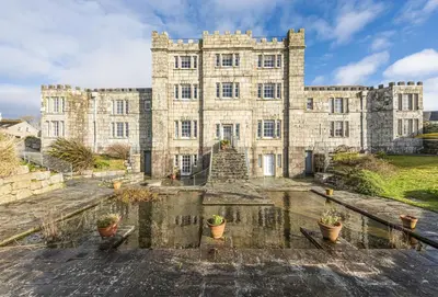 an old castle with potted plants in front of it at Acton Castle in Praa Sands