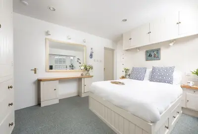 a white bedroom with a large bed and a window at Acton Castle in Praa Sands
