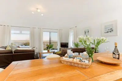 a living room with a table with a basket on it at Beau Vista GF in Padstow