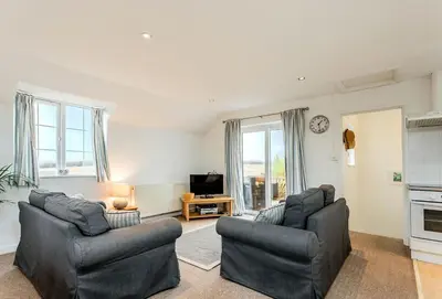 a living room with two couches and a tv at Arnold Cottage in St Merryn