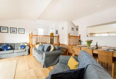a living room with couches and a dining room at Bay View in Port Isaac