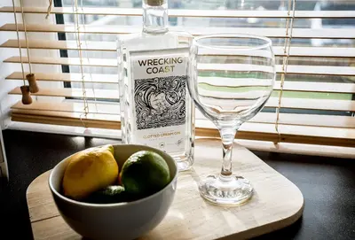 a bottle of wine and a bowl of fruit next to a glass at Bay View in Port Isaac