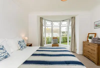 a bedroom with a bed and a window at Bay View in Port Isaac