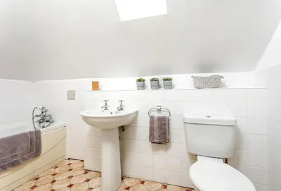 a white bathroom with a toilet and a sink at Bay View in Port Isaac