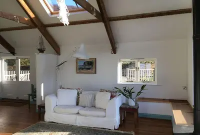 a living room with a white couch and windows at Lower Hillcott in Bude