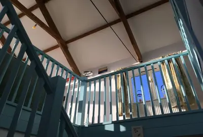 a staircase with a blue railing in a building at Lower Hillcott in Bude