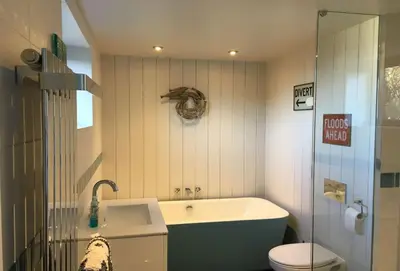 a bathroom with a tub and a toilet at Lower Hillcott in Bude