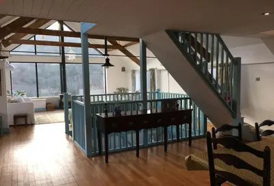 a living room with a staircase in a house at Lower Hillcott in Bude