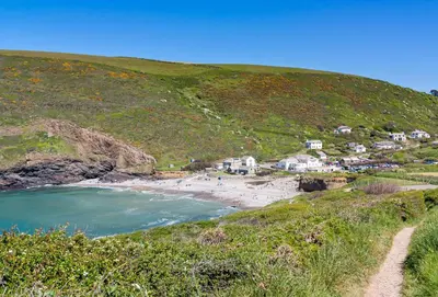 a view of a beach with houses on a hill at Lower Hillcott in Bude