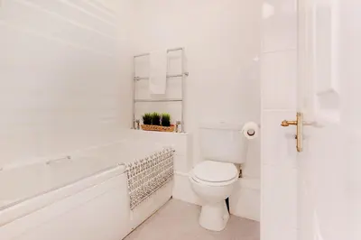 a white bathroom with a tub and a toilet at Beau Vista FF in Padstow