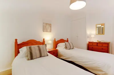 two beds in a bedroom with white walls at Beau Vista FF in Padstow