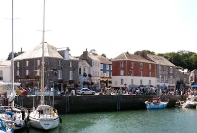 a group of boats docked in a harbor with buildings at Primrose Cottage in St Merryn