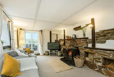 a living room with a couch and a fireplace at Primrose Cottage in St Merryn
