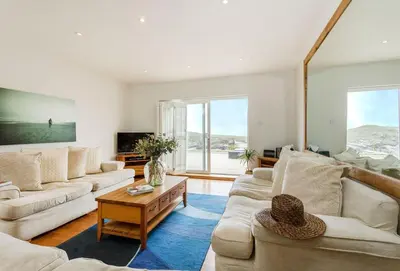 a living room with two couches and a table at Surfside in Newquay