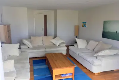a living room with two white couches and a coffee table at Surfside in Newquay