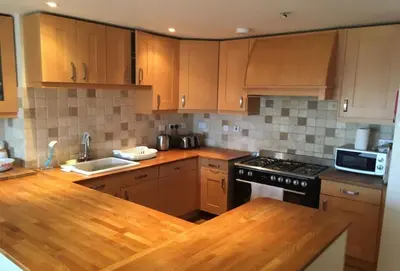 a kitchen with wooden cabinets and a stove top oven at Surfside in Newquay