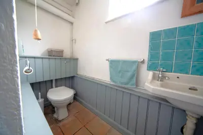 a bathroom with a toilet and a sink at Penrose Cottage in Bude