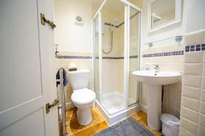 a bathroom with a toilet and a sink and a shower at Penrose Cottage in Bude