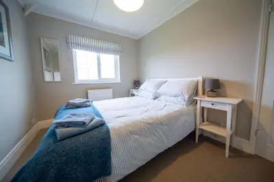 a small bedroom with a bed and a window at Penrose Cottage in Bude