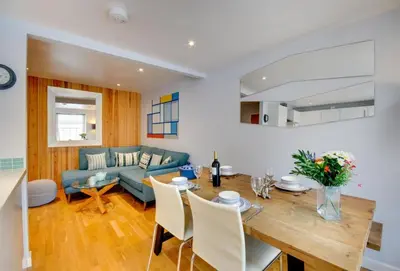 a living room with a table and a blue couch at Quayside in Fowey