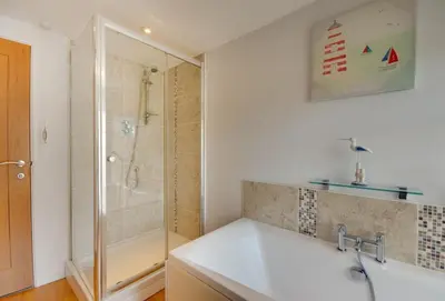 a bathroom with a shower and a white sink at Quayside in Fowey
