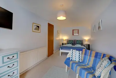 a living room with a couch and a bed at Quayside in Fowey
