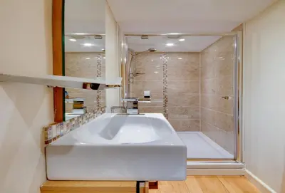a bathroom with a large white sink and a shower at Quayside in Fowey