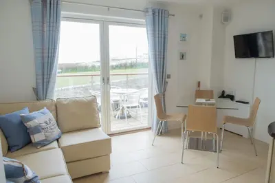 a living room with a couch and a table at The Treyarnon Suite in St Merryn