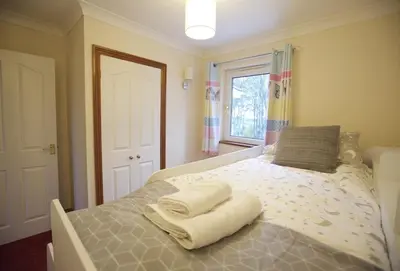 a bedroom with a bed with towels on it at Woodlands in Newquay
