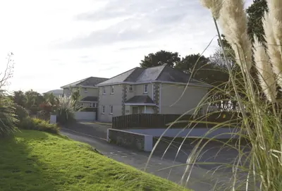 a large white house with a driveway at Woodlands in Newquay