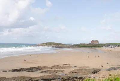 a group of people on a beach near the ocean at Woodlands in Newquay