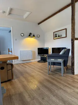 a living room with a couch and a table at Titmouse at Trenale Court Cottages in Tintagel