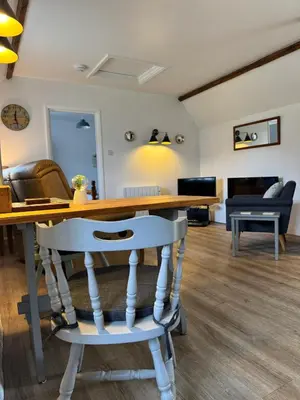 a living room with a table and a couch at Titmouse at Trenale Court Cottages in Tintagel